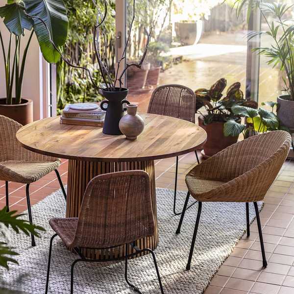 A wooden dining table with rattan dining chairs.
